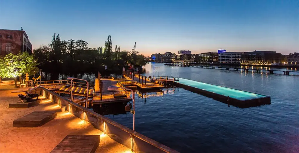 The Badeschiff pool in Berlin at night during a heat wave in Europe.